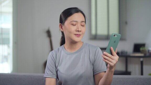亚洲女性在家里用智能手机进行视频通话
