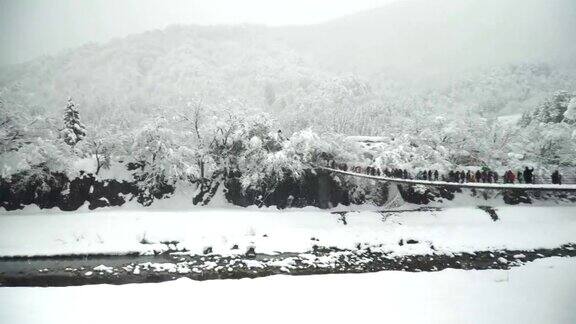 淘金:Shogawa河和旅客将通过吊桥前往shirakawa村