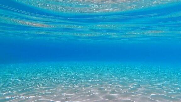 透明的空蓝色水下景观和白色的沙子在浅水的海底热带副本空间背景