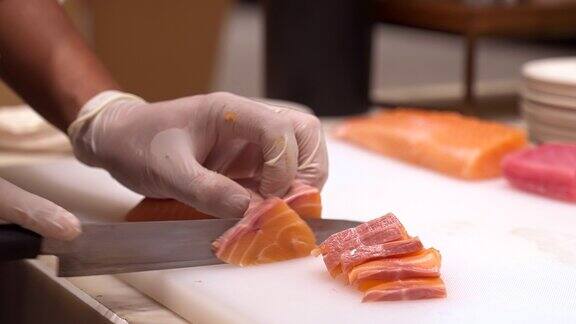 4K超高清慢动作手持:拉近厨师的手切生鲑鱼作为生鱼片日本美食