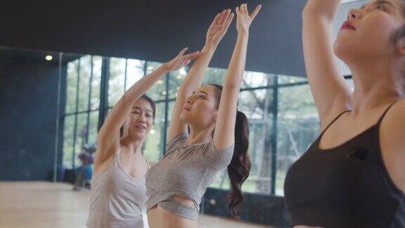 年轻的亚洲运动员与教练练习瑜伽课亚洲女性群体在健身室锻炼健康的生活方式体育活动体操或芭蕾课缓慢的运动