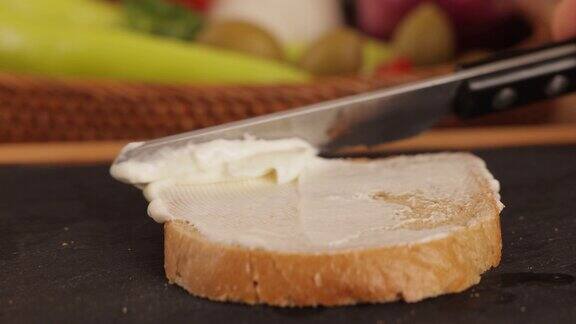 把奶油干酪涂在面包上