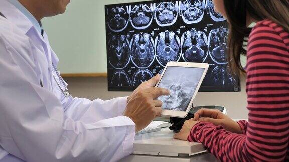 医生和病人谈论x光图像的数字平板电脑