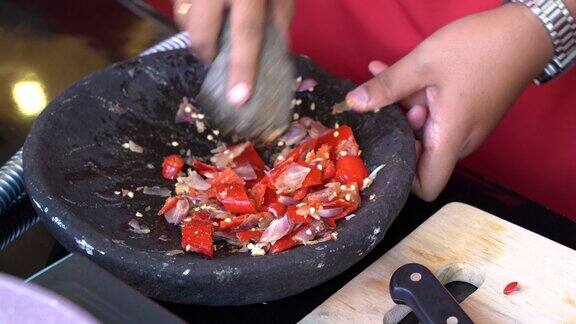 用研钵和杵把洋葱和红辣椒切碎印尼