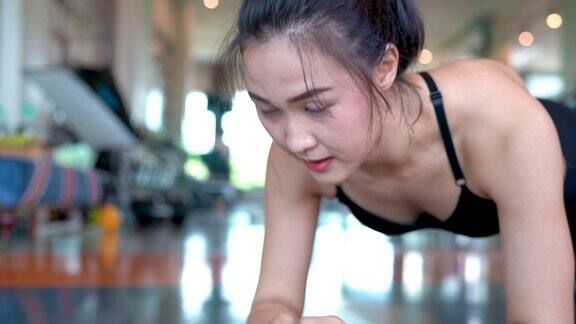运动女性做平板支撑在健身房锻炼健身运动员腹肌建立强壮健康的生活方式慢动作4k分辨率