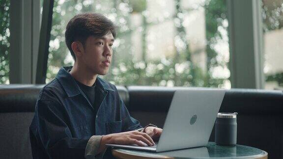 亚洲男人用笔记本电脑工作