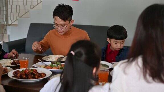 在中国新年期间快乐的亚洲家庭的三代人在家里庆祝和享受团圆饭