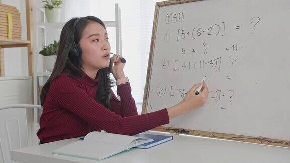美丽的亚洲女人教数学在线微笑的亚洲女教师说录音视频或数学课程在线家教