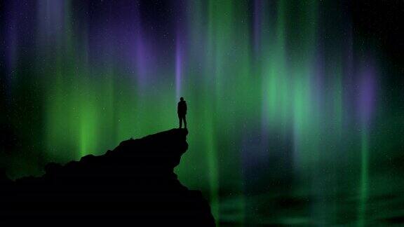 一个人的剪影站在悬崖边看着夜空和北极光