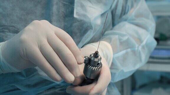 在骨折手术中外科医生更换手术钻的喷嘴外科医生使用医用钻头对骨折进行植骨术更换钻头上的喷嘴