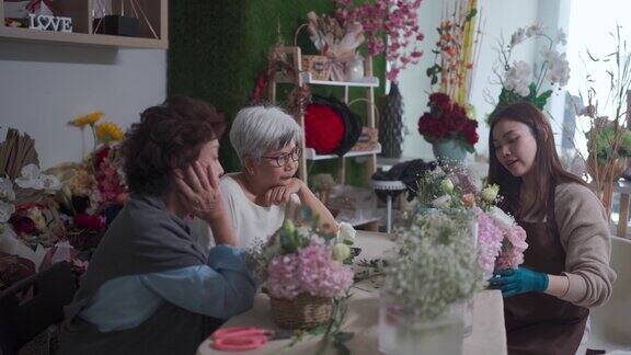 亚洲华人女花商展示插花给她的年长成人学生在她的工作坊班