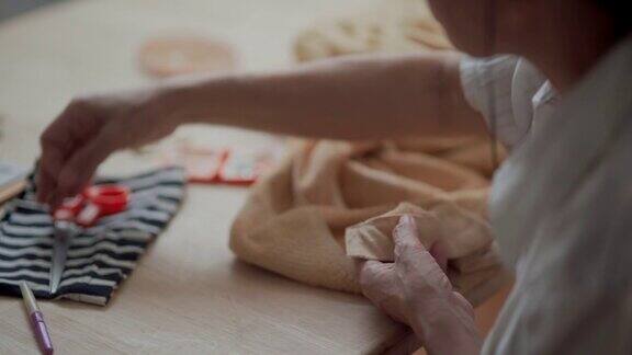 特写退休亚洲妇女缝纫她的衣服手工