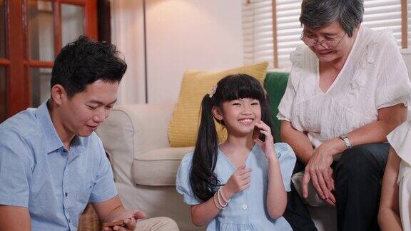 亚洲家庭与年轻女孩和老年妇女一起在公寓玩游戏