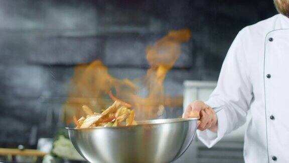厨师在厨房用火将锅内点燃不断翻炒