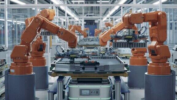 配备橙色先进机械臂的电动汽车电池组自动化生产线光明工厂内的一排机械臂为汽车工业组装电池现代电动汽车智能工厂