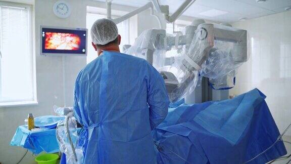 医生用手术机器人做手术在现代诊所的机器人手术期间外科医生看着监视器的后视图