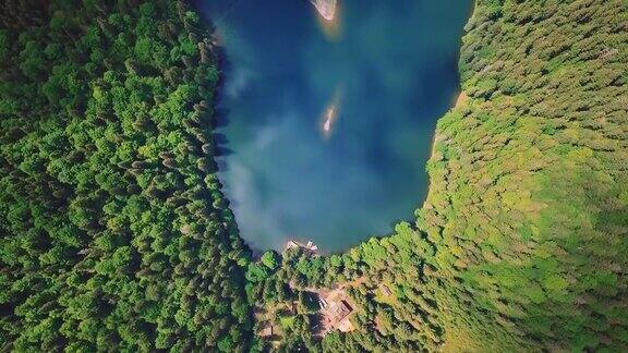 空中飞过美丽的山脉、森林和蓝色的湖泊从鸟瞰的垂直视图