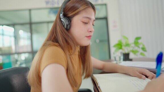 一名年轻的亚洲大学生戴着耳机在家在线学习在病毒爆发期间没有上大学