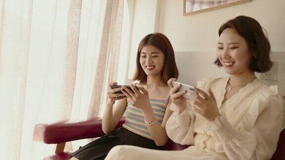 年轻的亚洲女性玩手机游戏