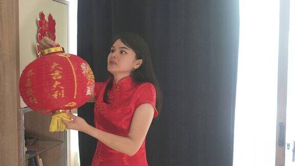 美丽的年轻亚洲妇女装饰她的房子为中国新年