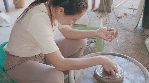 用陶工轮制作陶器的妇女