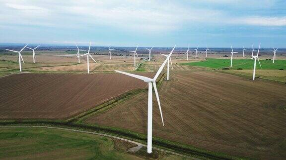 无人机航拍的风力涡轮机在农田里转动