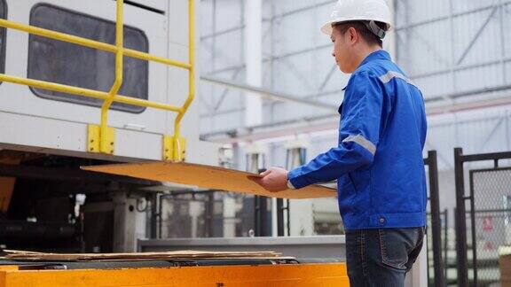 工程师工人保持最高标准的质量控制工人正在从造纸厂的专用机器中取出穿孔瓦楞纸板仔细检查每一块瓦楞纸板