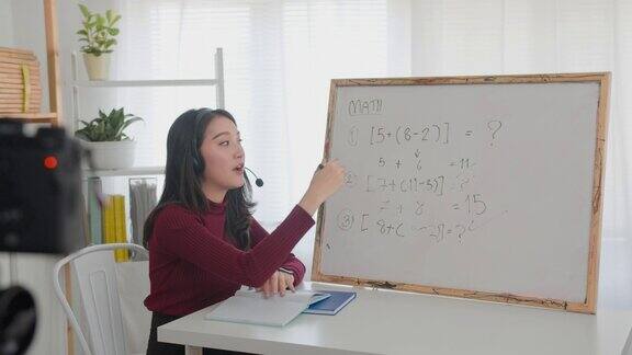 美丽的亚洲女人教数学在线微笑的亚洲女教师说录音视频或数学课程在线家教