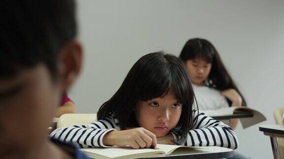 亚洲孩子对学习不感兴趣在学校的教室里懒惰和困倦教育