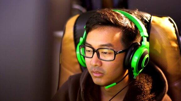 亚洲人游戏在咖啡馆与绿色游戏耳机