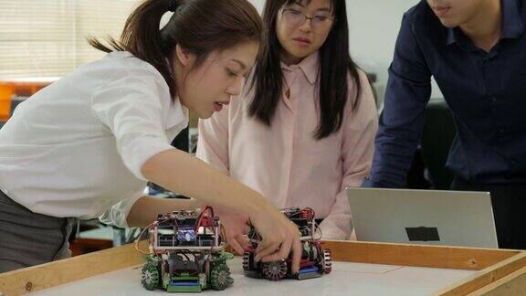 机器人工程师团队与机器人一起工作在车间用笔记本电脑组装和测试机器人的响应有技术或创新观念的人