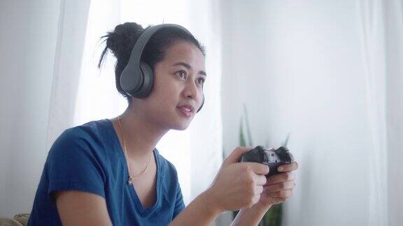 亚洲女人在家里的客厅玩电子游戏