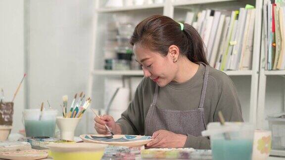 4K亚洲妇女喜欢画自制的陶器工作室