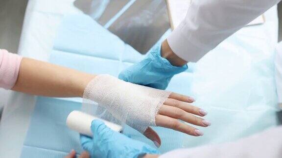 医生创伤学家包扎病人的手与绷带在诊所特写4k电影