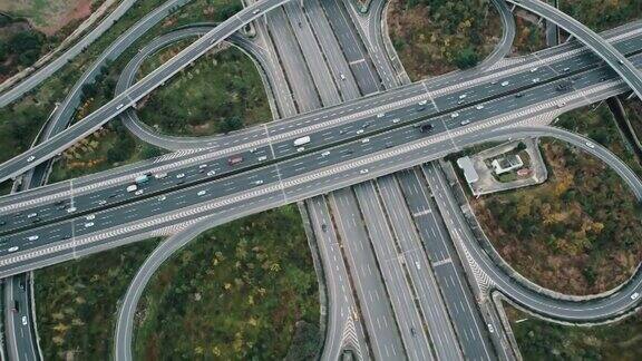 从无人机上俯视大城市多车道高速公路现代交通枢纽高速公路上交通拥挤高架弯道三叶草桥无车速限制