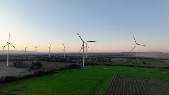 美丽的紫色黄昏山景观上的风力涡轮机生态农场为绿色生态世界生产可再生能源风车农场公园鸟瞰图