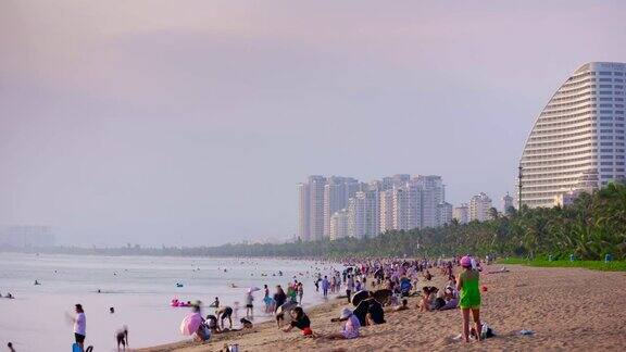 日落光线三亚拥挤的海滩海岸线全景4k时间推移海南岛中国