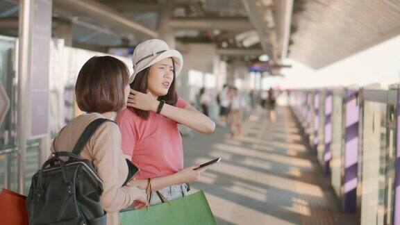 两名女游客在火车站站台等车时聊天RAWVDO拍摄的4k慢镜头