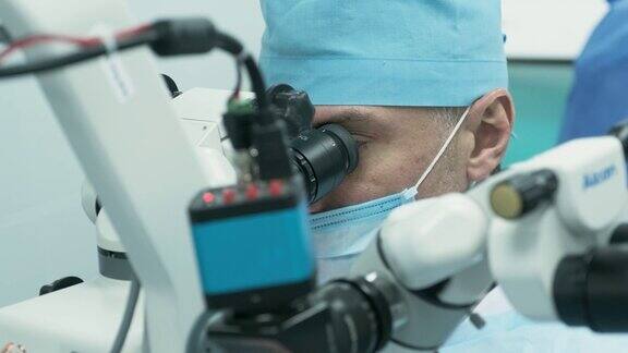 外科医生在手术室里用显微镜观察女病人的眼睛医生在眼科手术、白内障治疗和屈光度矫正过程中使用显微镜