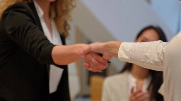 两个女商人在办公室握手达成协议