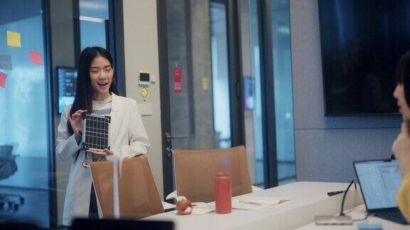 亚洲女商人向办公室同事介绍太阳能电池板的特性