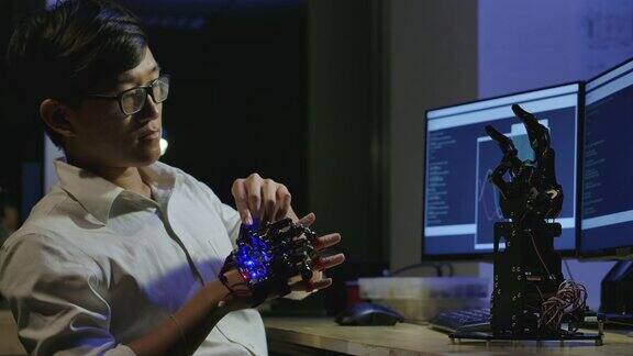 编码器程序机器人测试创新的机器人技术在实验室年轻的亚洲男性为机械机械手创造运动有技术或创新观念的人