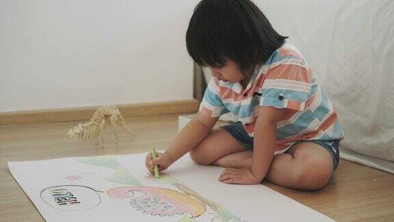 男孩正在用蜡笔画恐龙