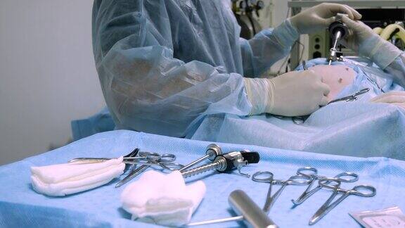 在手术室里无菌手术器械放在一张盖着蓝布的桌子上背景中正在对动物进行内窥镜手术手术