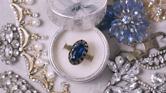 美丽的金戒指与蓝宝石宝石白色背景的复古珠宝珠宝旋转特写特写微距摄影棚拍摄
