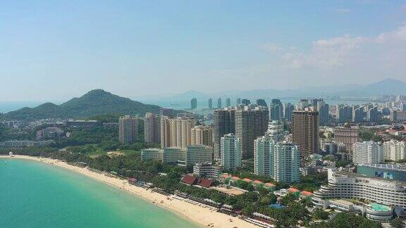 阳光明媚的三亚著名的大东海拥挤的海滩湾空中全景4k海南中国