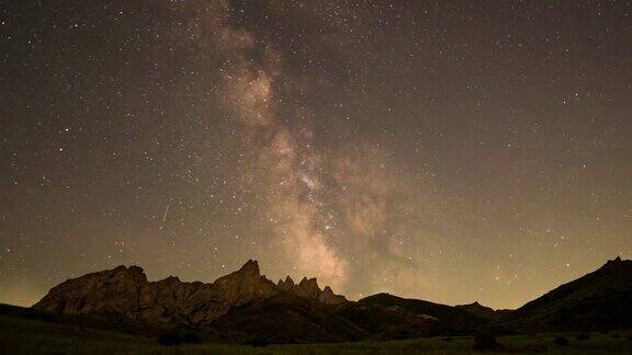 在群山的衬托下银河在夜空中运动