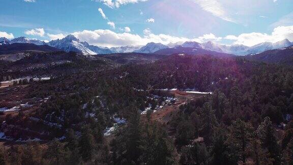 卡车前进的无人机拍摄的森林和雪峰的圣胡安山脉(落基山脉)外特柳赖德科罗拉多州在一个明亮的冬天的一天