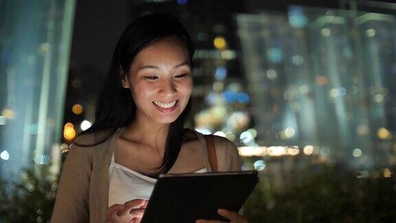 亚洲女性在晚上使用数字平板电脑