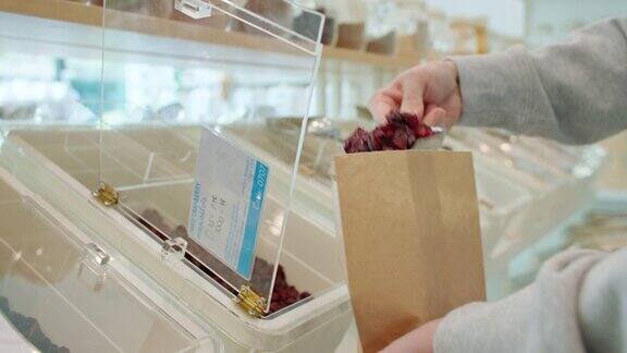 在零废物商店里人们用有机生物食品填充可重复使用的纸袋